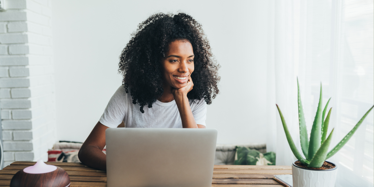 Person on laptop looking off into distance