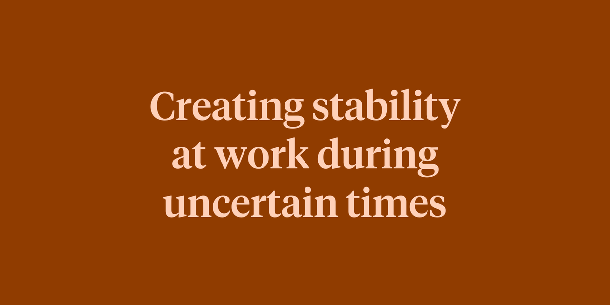 Text reading "Creating stability at work during uncertain times" on a dark burnt orange background.