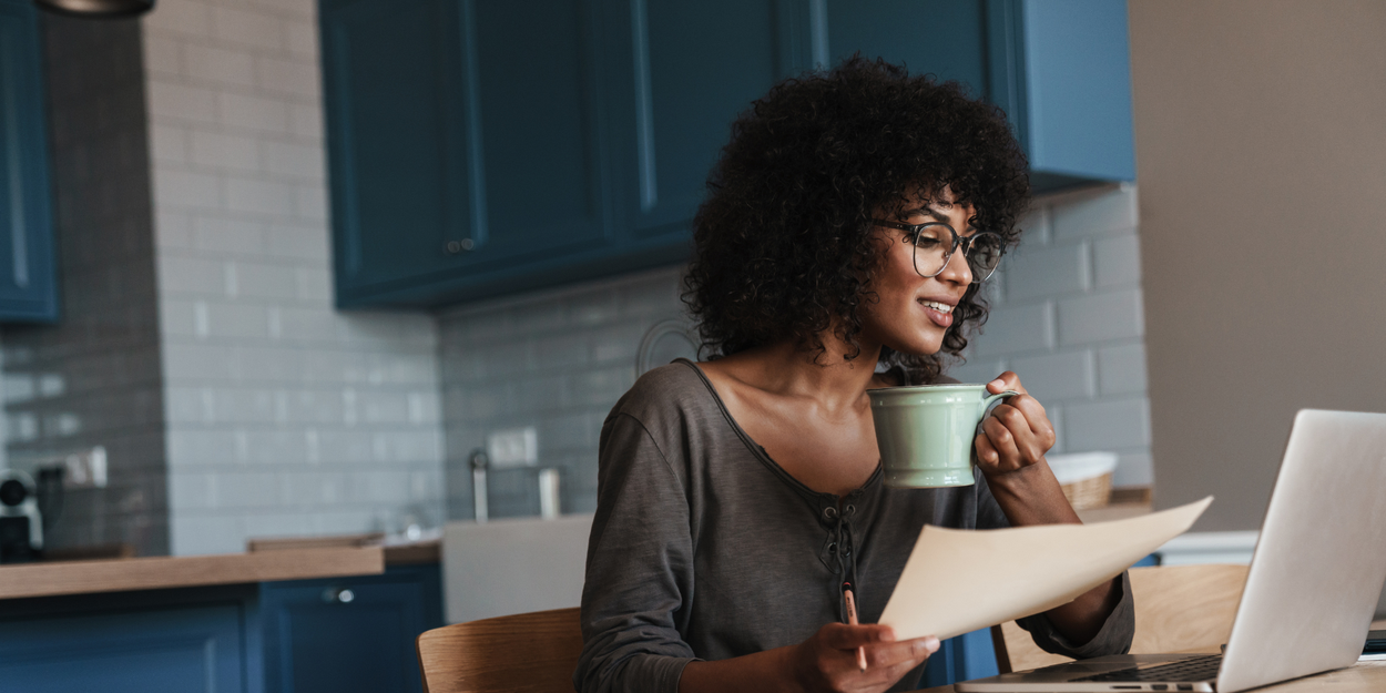 Woman on laptop drinking coffee and working